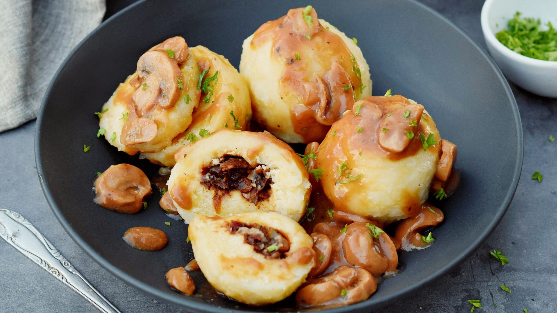 horizontal photo of best stuffed potato dumplings with mushroom gravy