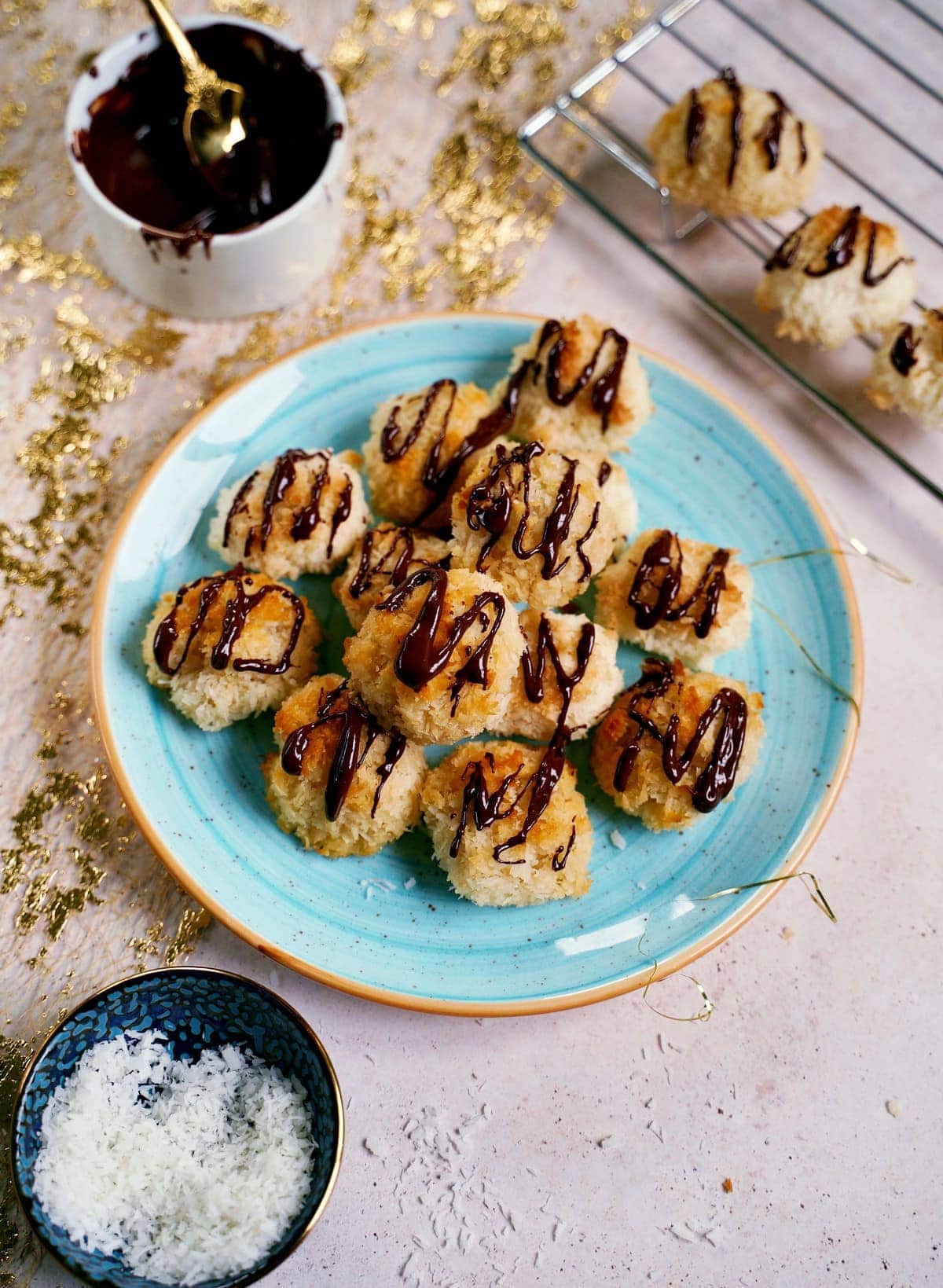 vegan coconut macaroons drizzled with chocolate on blue plate