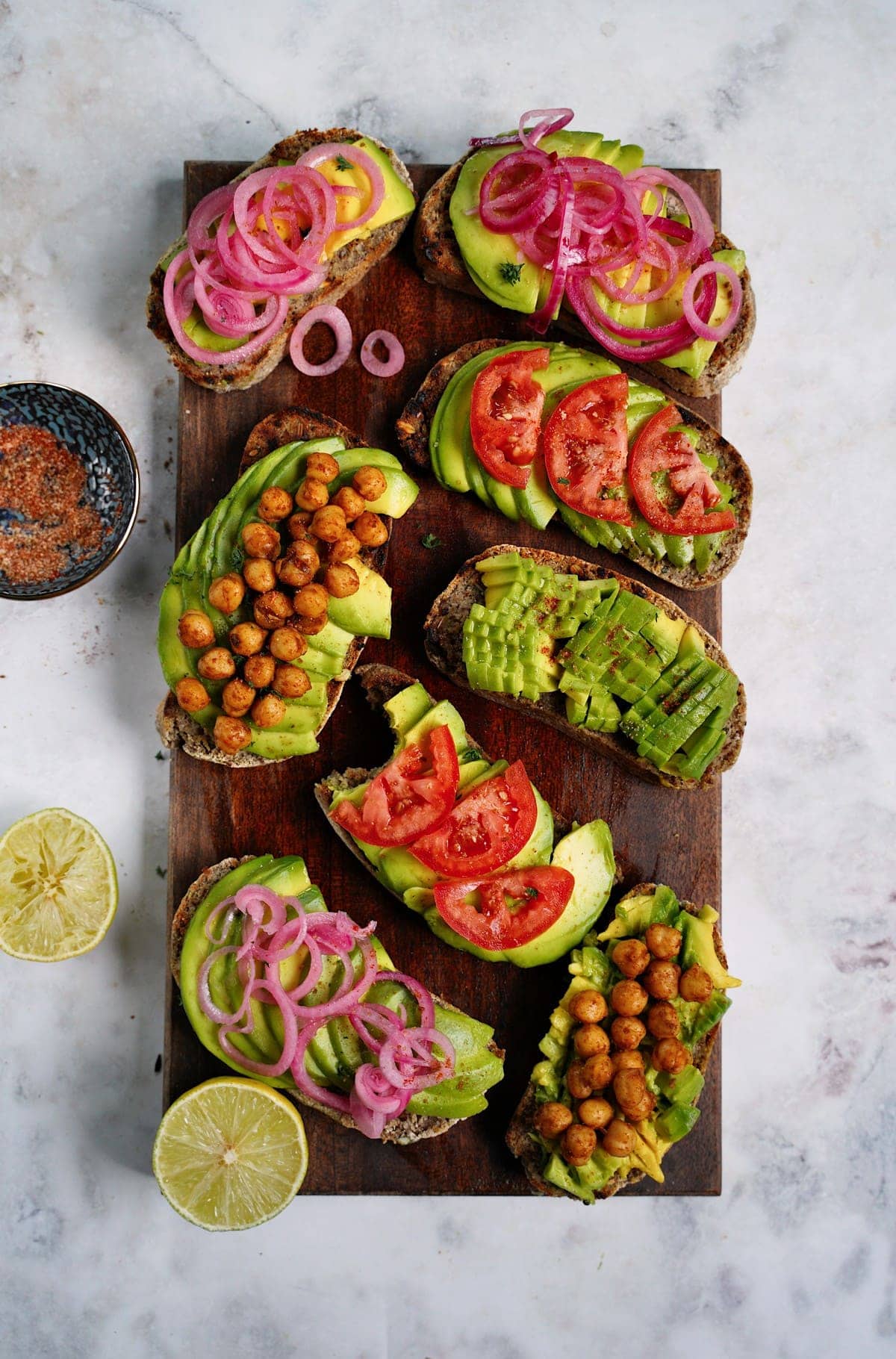8 avocado toast on wooden board with colorful toppings
