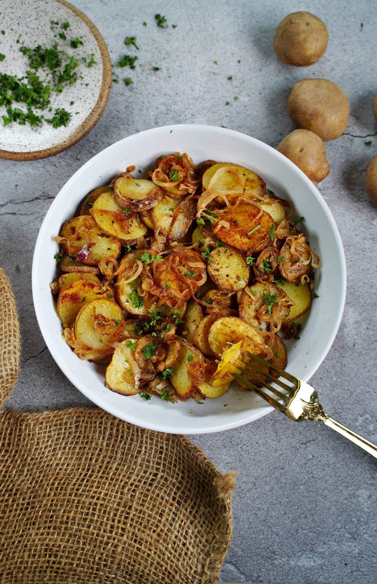 Lyonnaise pan-fried Potatoes with onions in white bowl