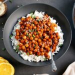 Sweet and Sour Chickpeas over rice in black bowl