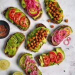 avocado toast on white marble with colorful toppings