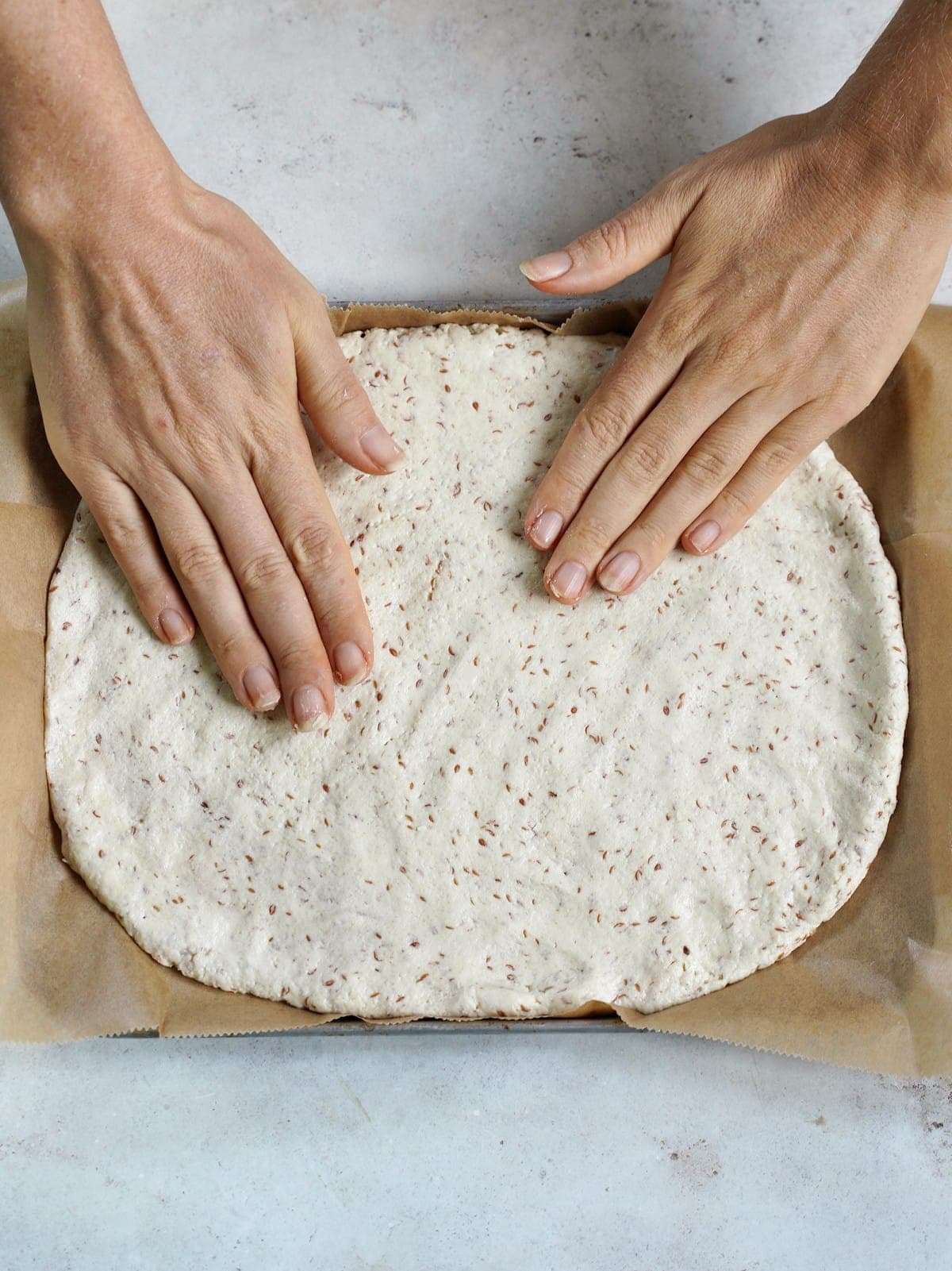 fingers spread out gluten-free pizza dough