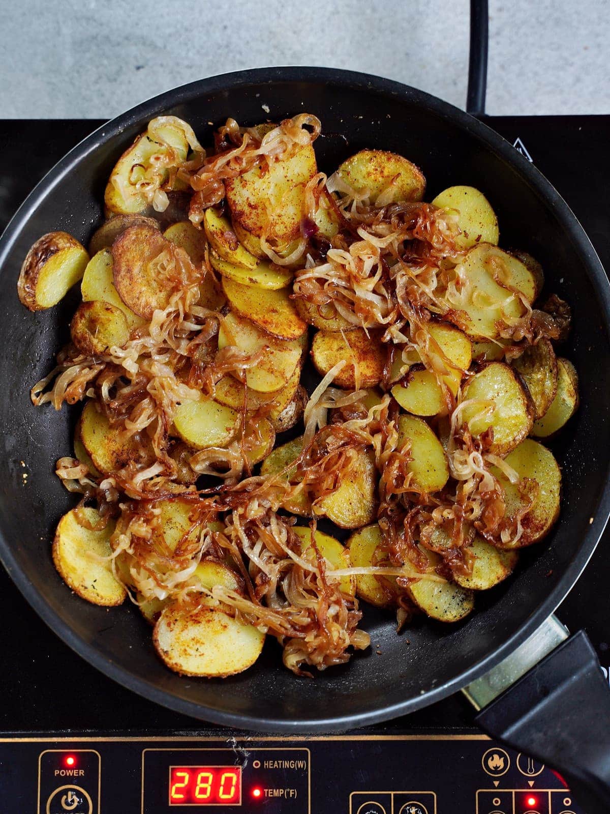 pan-fried potatoes and caramelized onions in black skillet