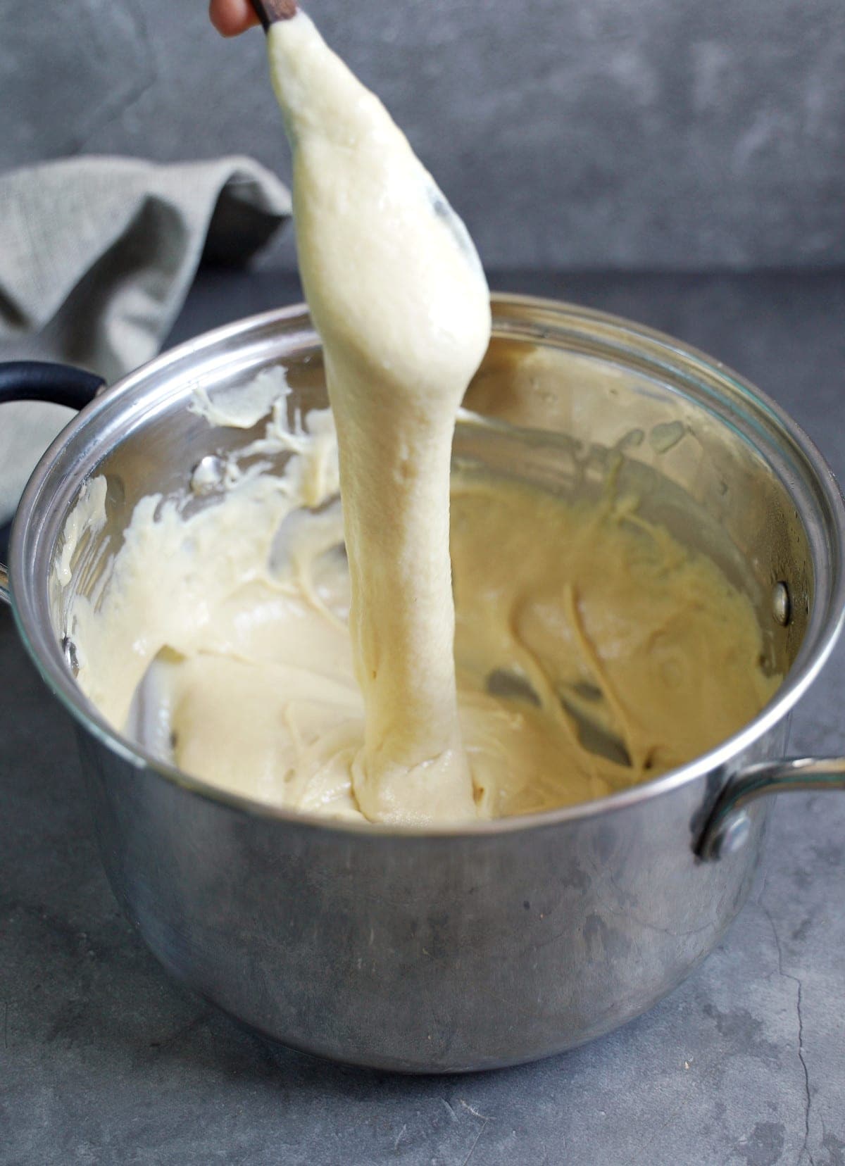 stretchy vegan mozzarella on spoon in saucepan