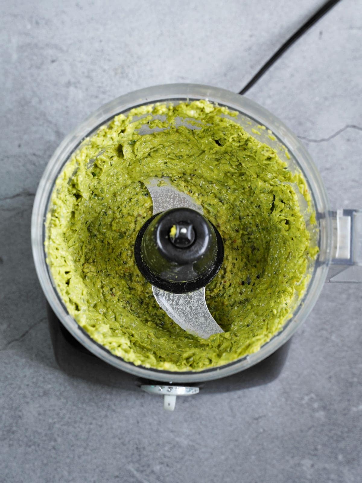 püriertes veganes Avocado-Pesto in einer Küchenmaschine
