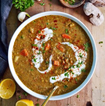 creamy vegan lentil soup in bowl with coconut cream and spoon