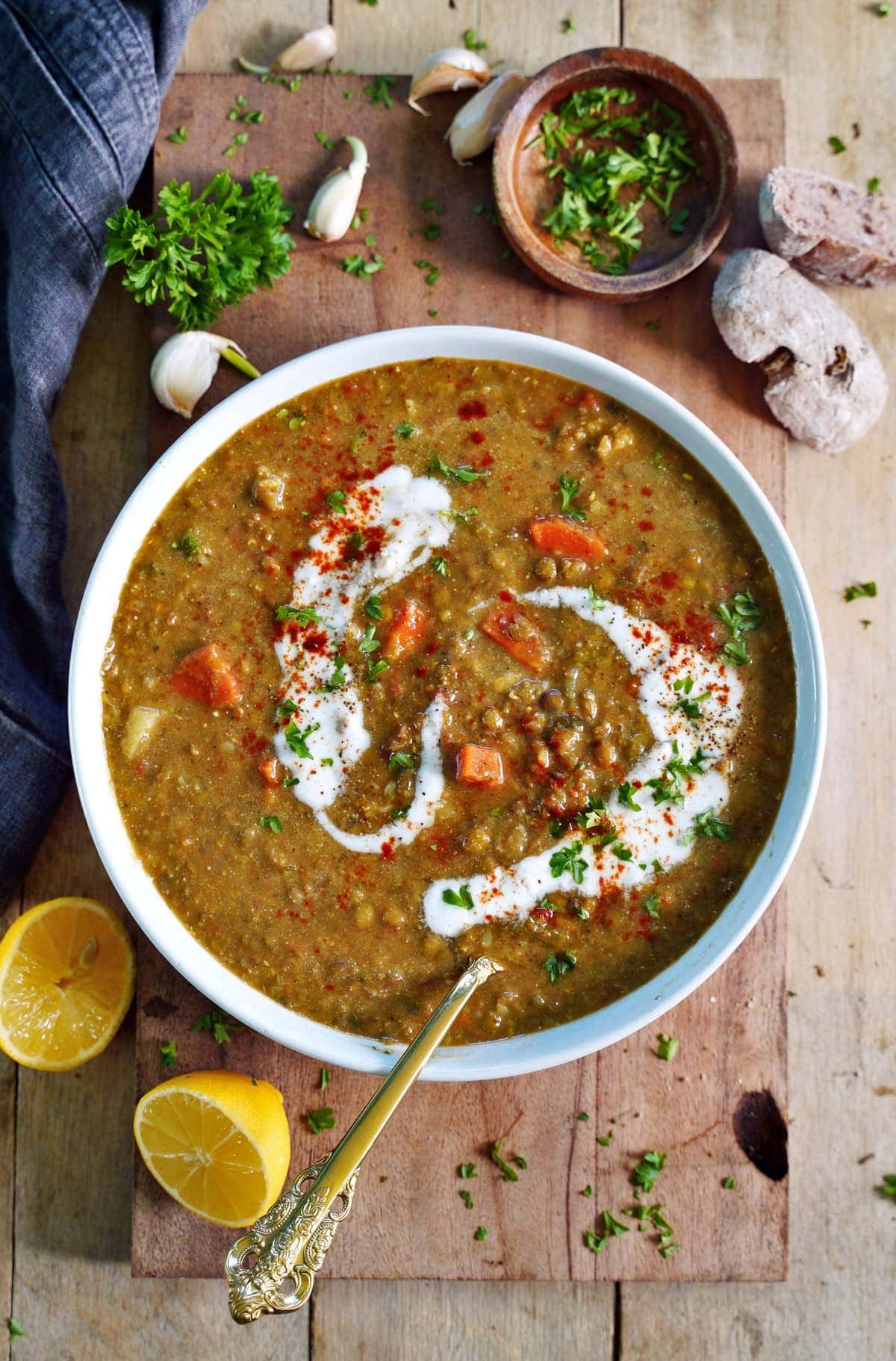 creamy vegan lentil soup in bowl with coconut cream and spoon