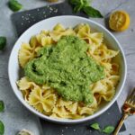 pasta in bowl with green basil avocado pesto in the middle