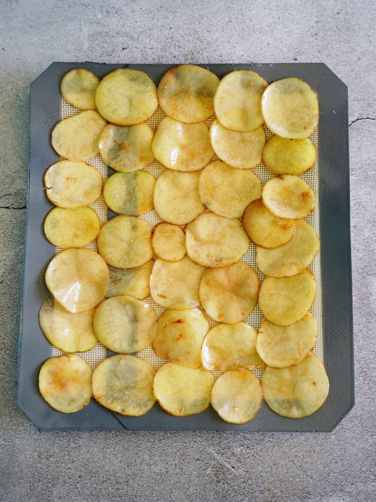 Kartoffelchips vor dem Backen im Ofen auf einer Silikonmatte