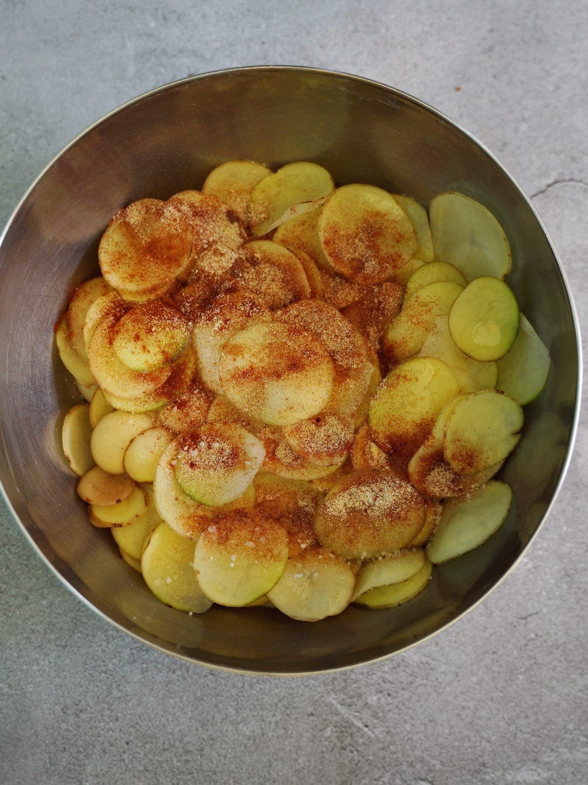 in Scheiben geschnittene Kartoffeln in Schüssel mit Gewürzen