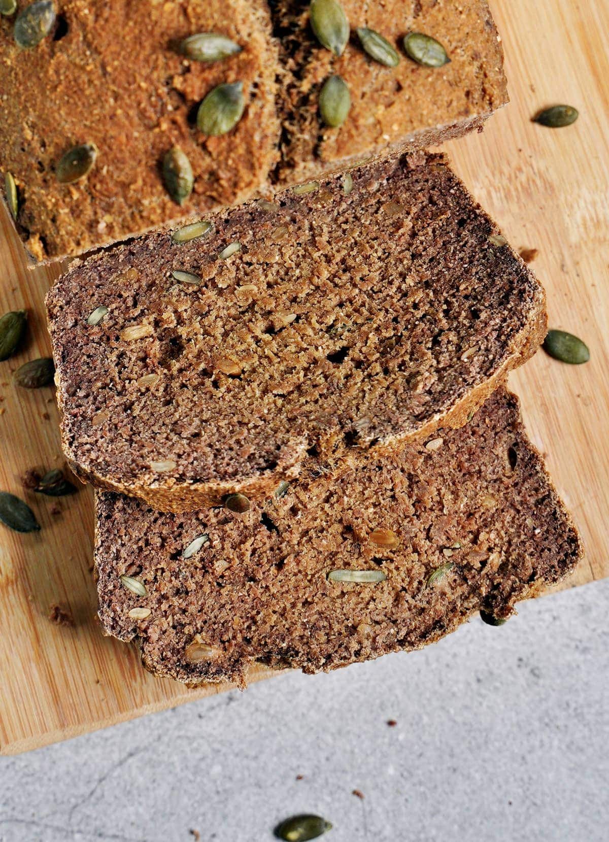 2 slices of healthy vegan protein bread with pumpkin seeds on wooden board