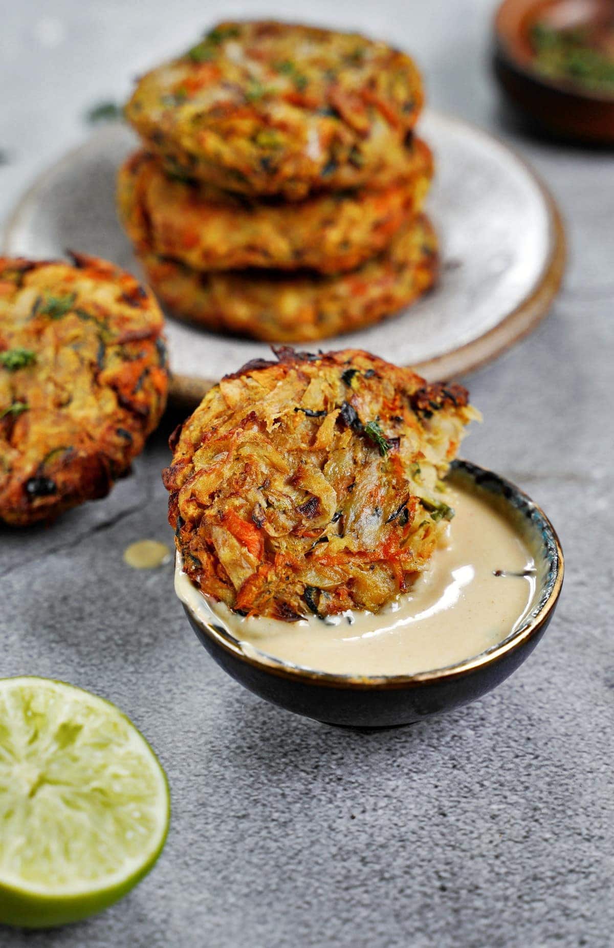 a vegetable fritter dipped in creamy white sauce