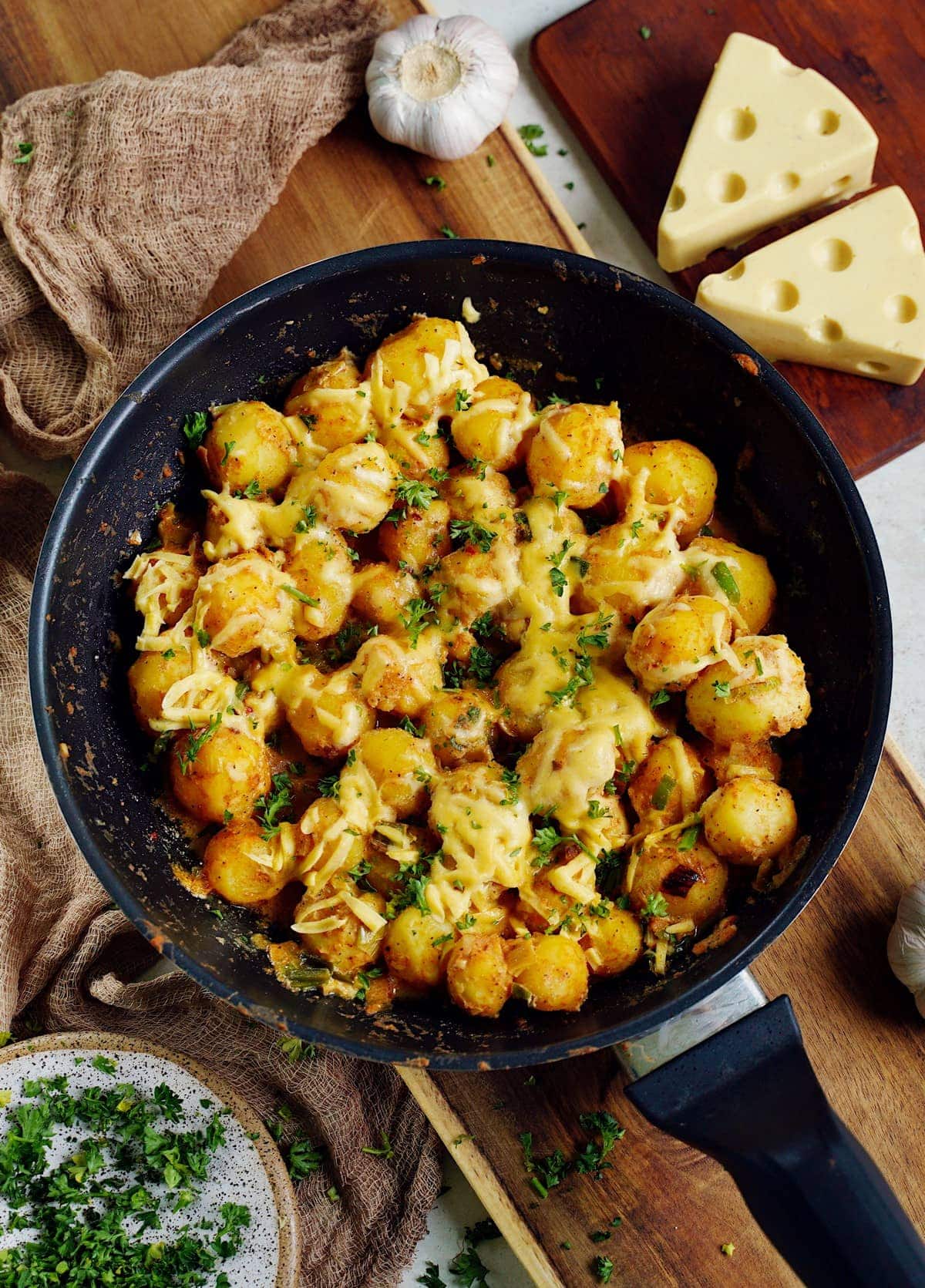 cheesy baby potatoes in a skillet