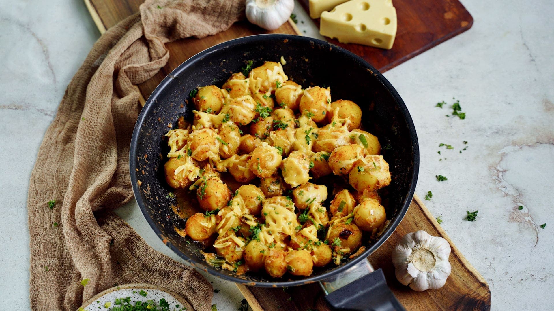 horizontal shot of baby potatoes in a skillet with cheese