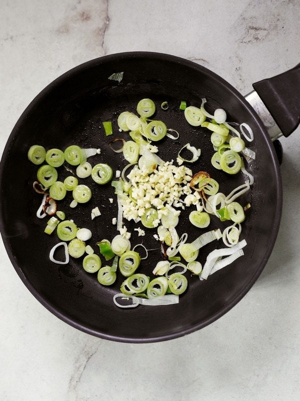 leek and garlic in a black pan