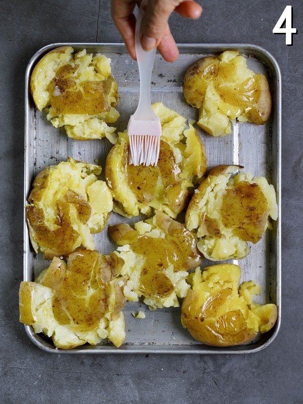 smashed potatoes on baking sheet before baking brushed with oil