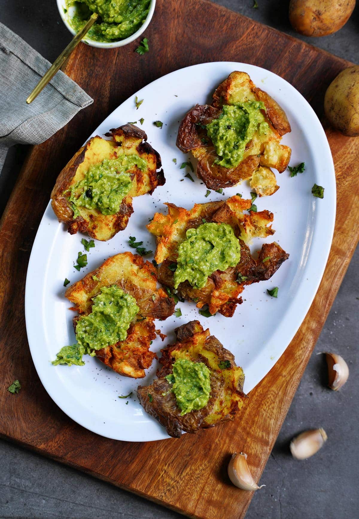 air fryer smashed potatoes with avocado pesto on white plate