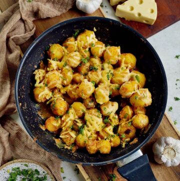 top shot of cheesy baby potatoes in black skillet