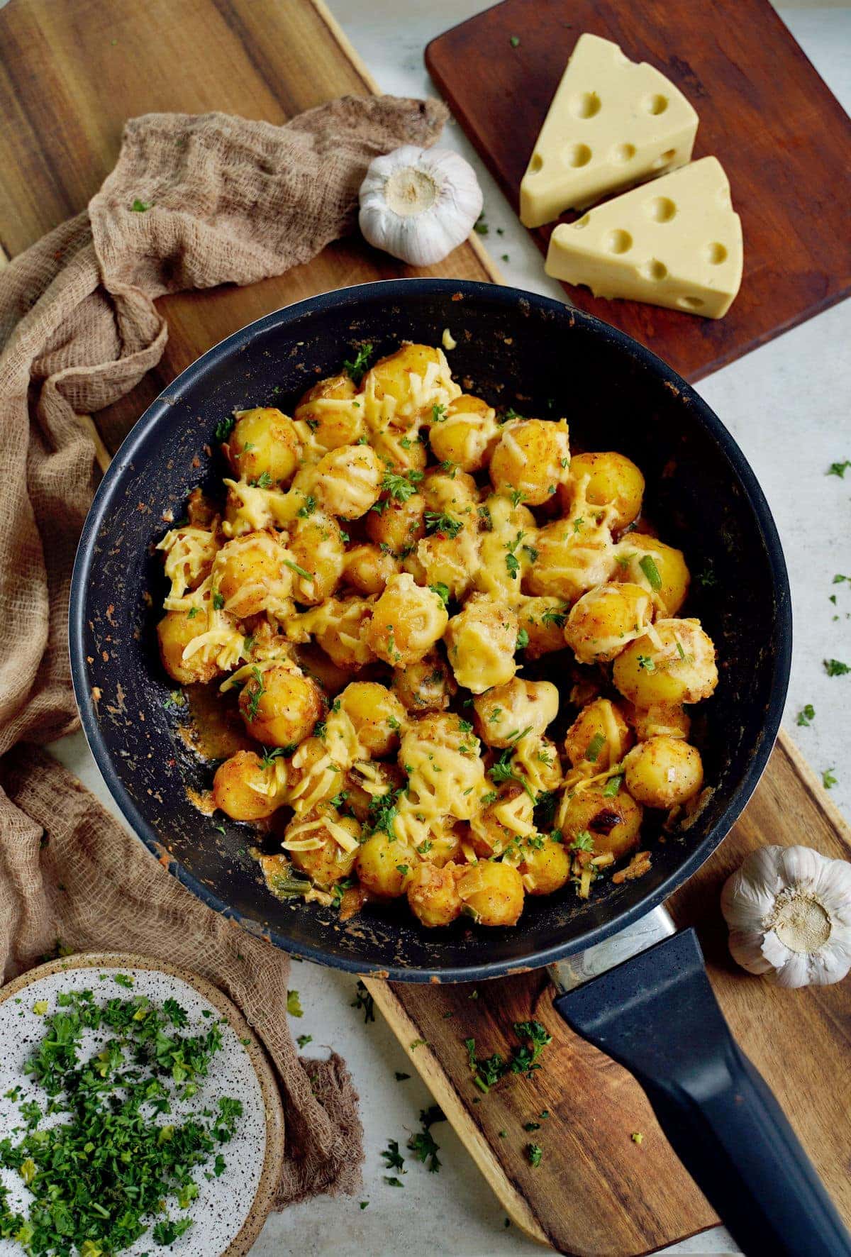 top shot of cheesy baby potatoes in black skillet