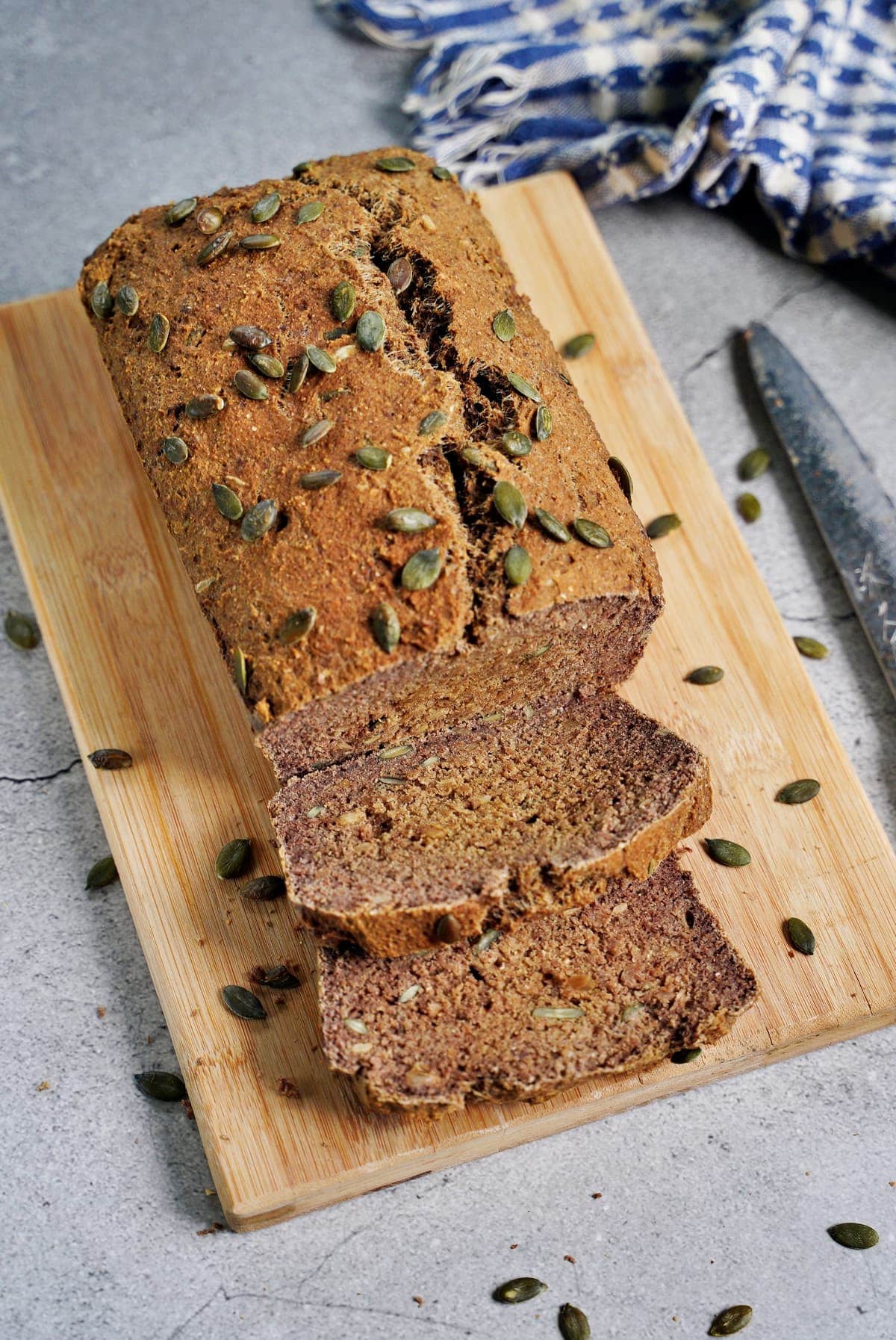 top shot of gluten-free protein bread with pumpkin seeds on wooden board