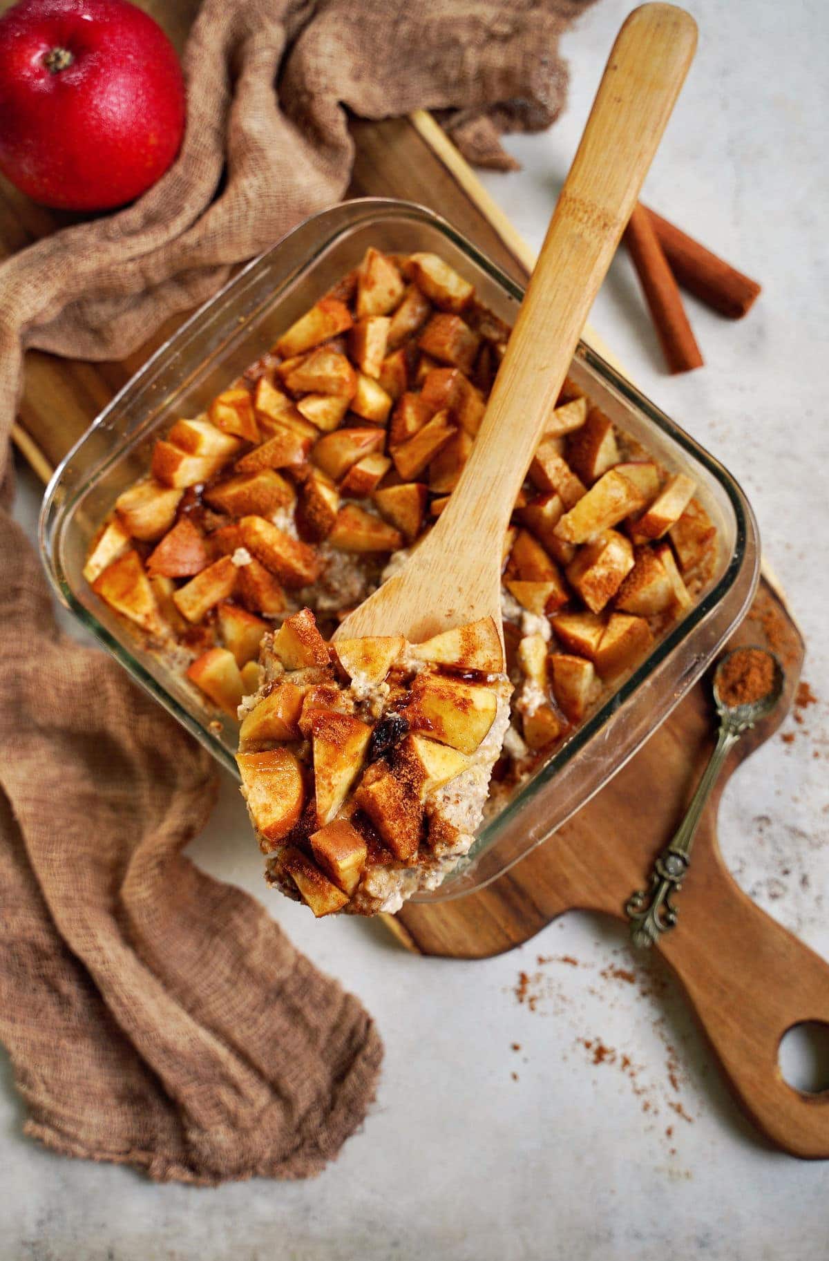 baked apple cinnamon oatmeal on wooden spoon over pan