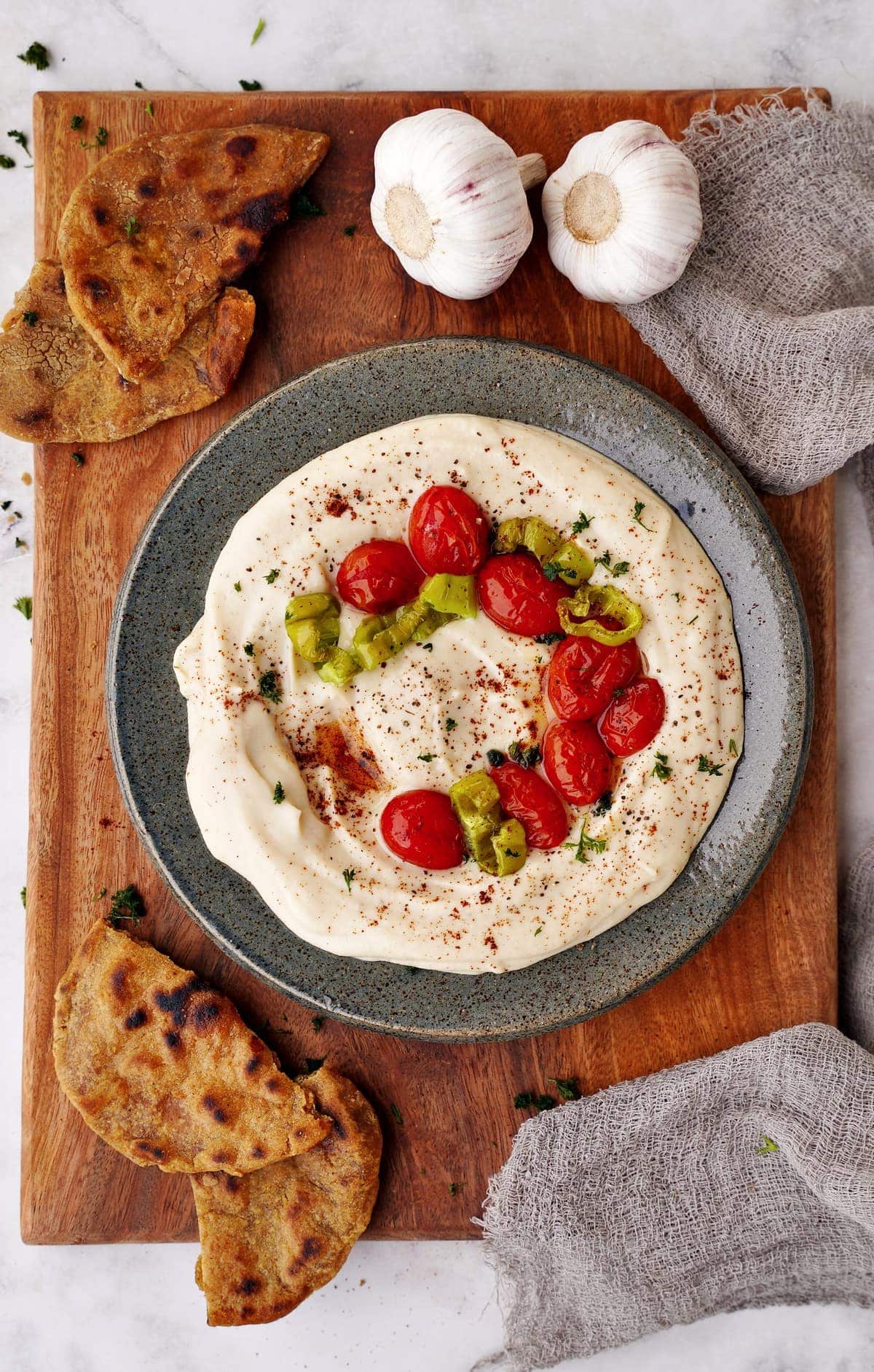 cannellini bean dip with roasted garlic, tomatoes and pepper in bowl