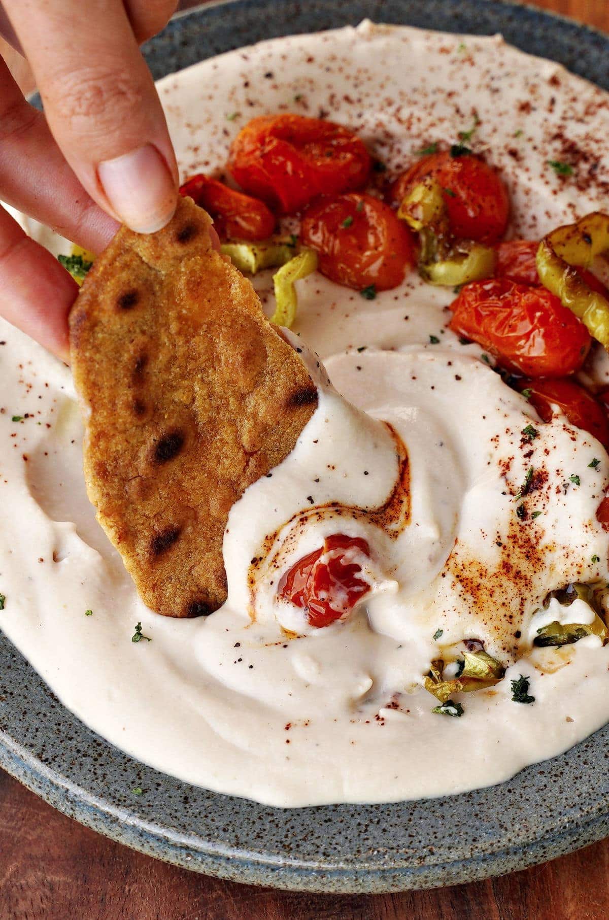 close-up of flatbread submerged in creamy dip