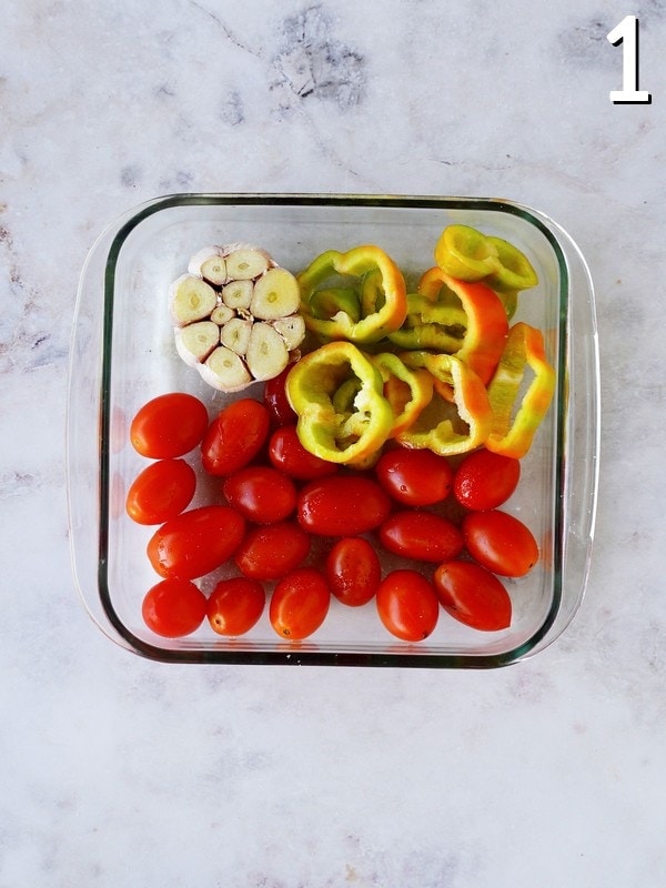 garlic, tomatoes, and sliced pepper in baking dish