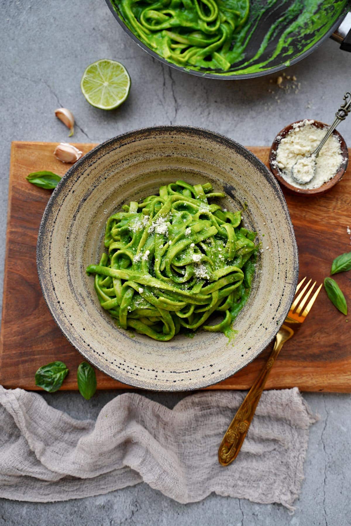 spinach and basil pasta with dairy-free Parmesan cheese in bowl from above