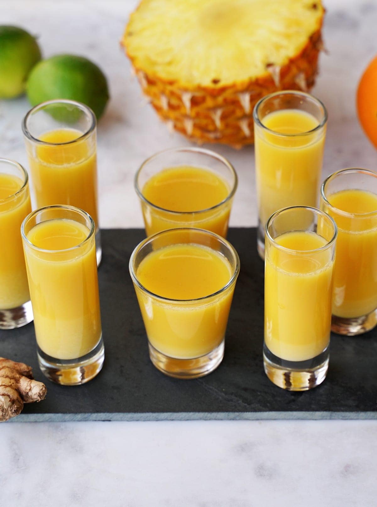 several ginger shots with pineapple, lime, and orange