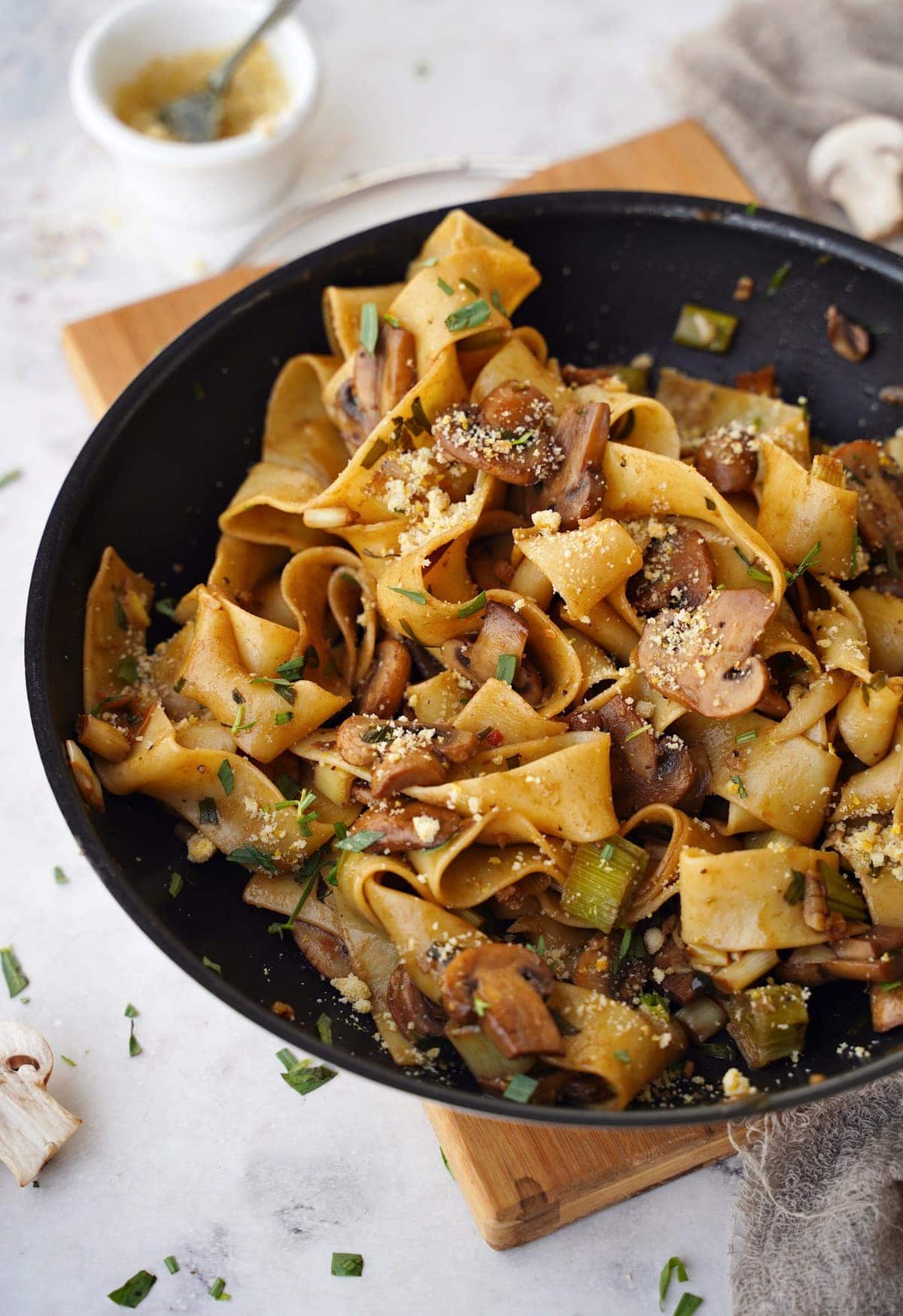 close-up of pappardelle in skillet with mushrooms and leek