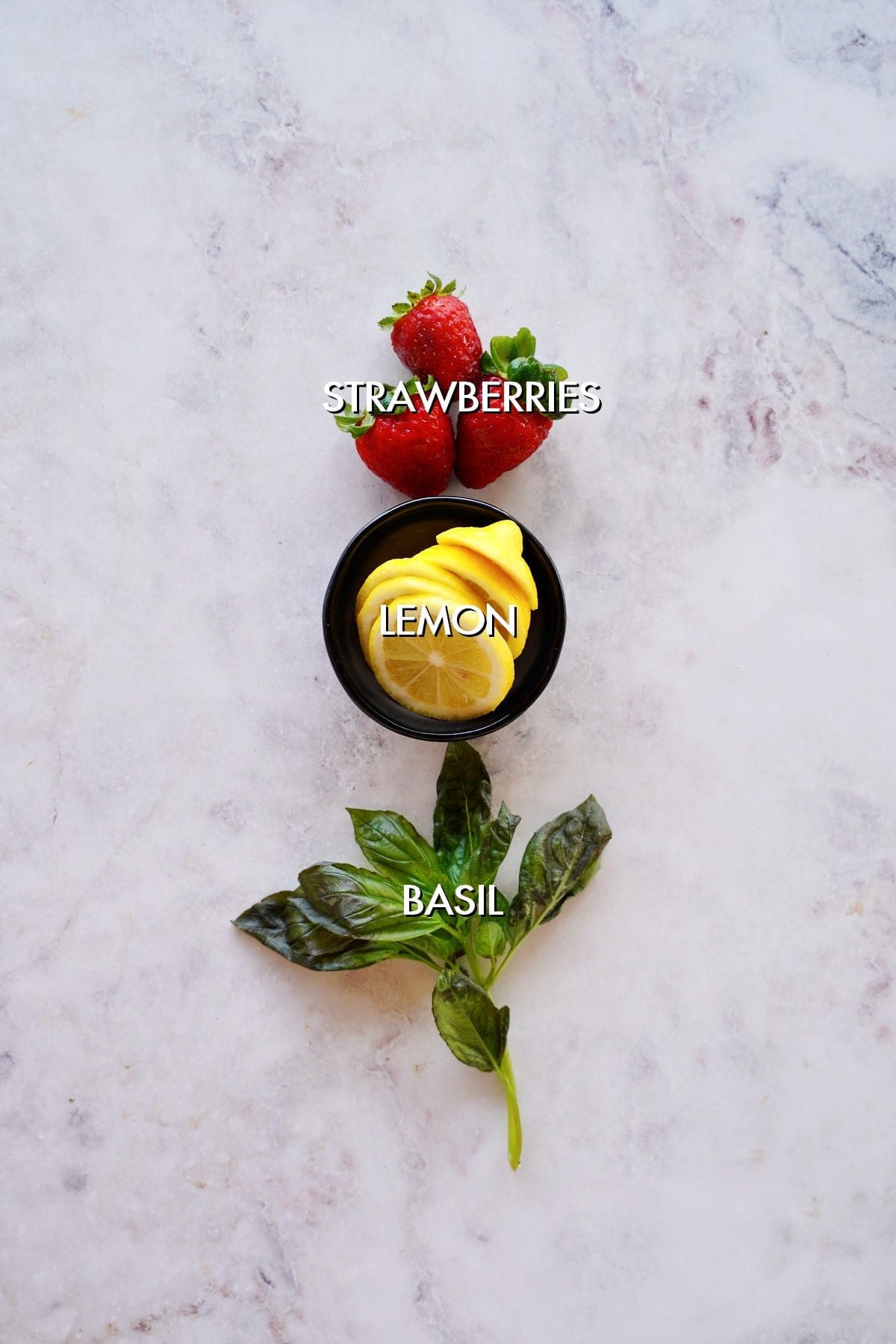 strawberries, lemon and basil on white backdrop
