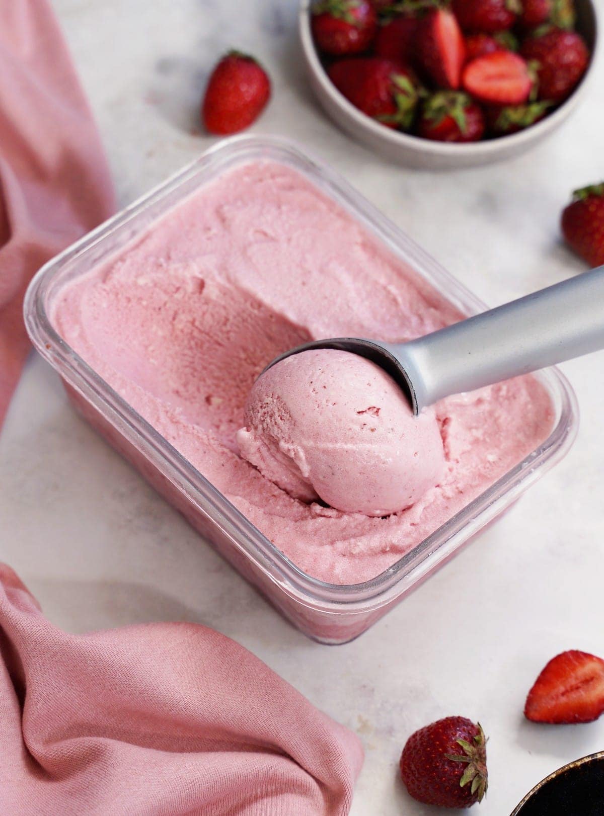 strawberry ice cream in dish with ice cream scoop