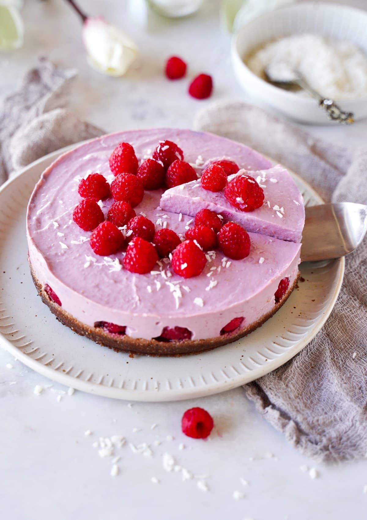vegan raspberry cheesecake with a slice being cut out