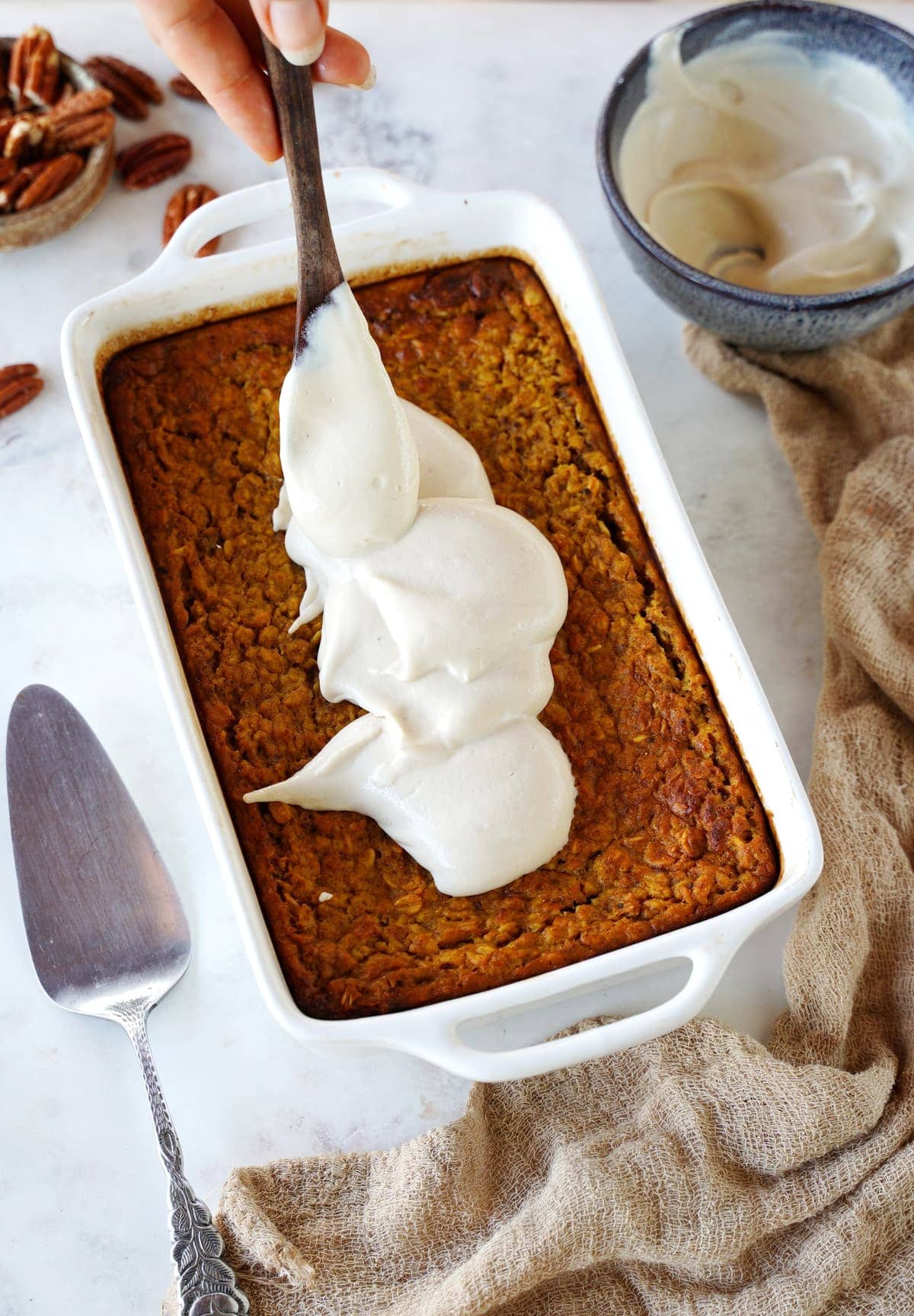 spreading dairy-free cream over pumpkin baked oatmeal