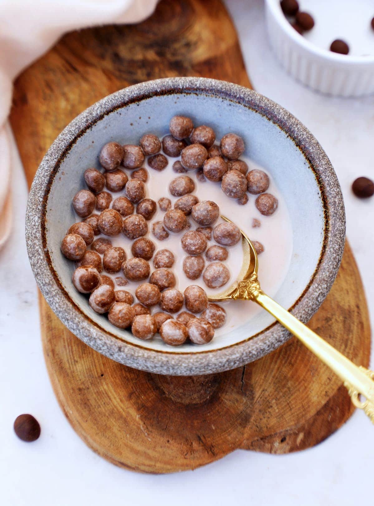chocolate cereal puffs in bowl with milk
