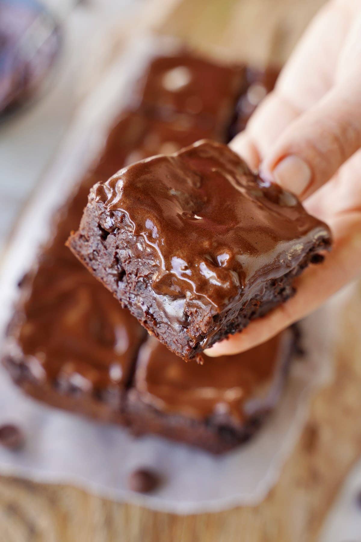 Hand hält einen veganen Brownie mit Schokoladencreme