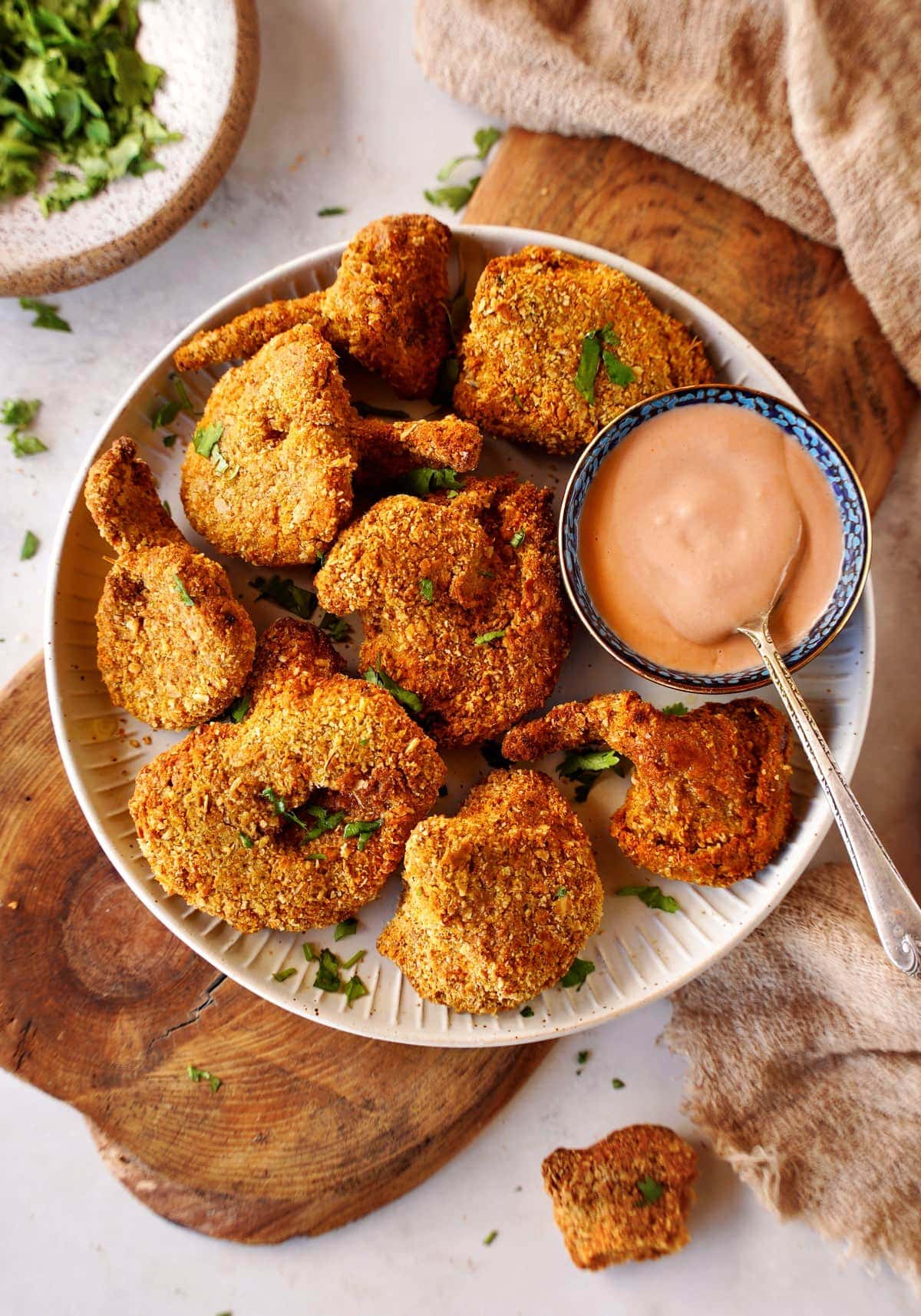 top shot of vegan fried chicken nuggets served with a dip