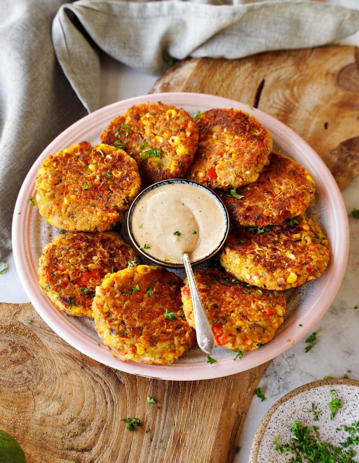 8 vegetable burgers on plate with white dip