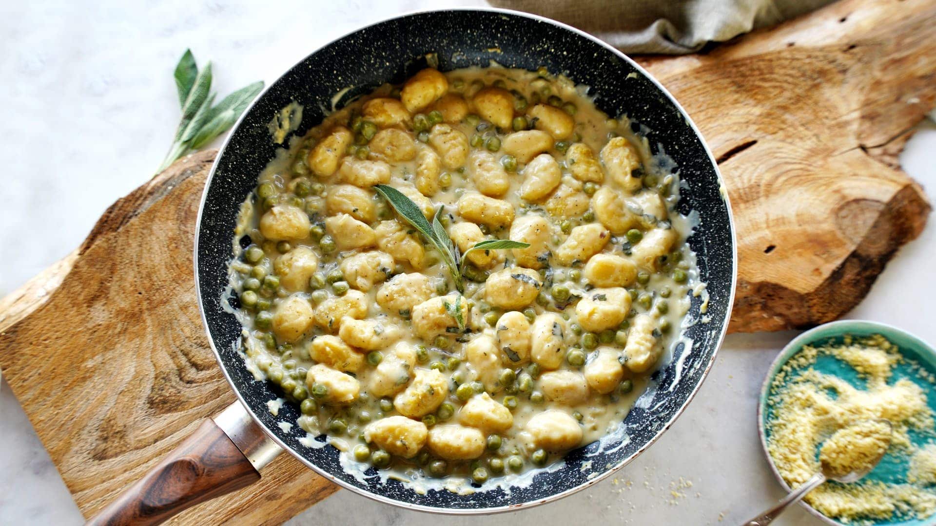 horizontal shot of sage gnocchi with creamy sauce in skillet