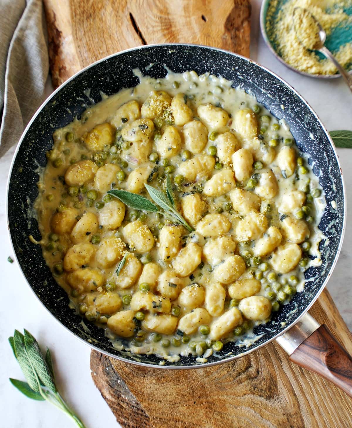 sage gnocchi with peas and cream sauce in skillet