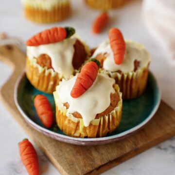 healthy carrot muffins with icing and marzipan carrots on small plate