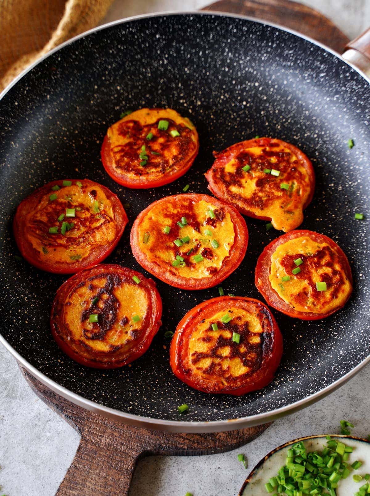 rings of vegan stuffed breakfast tomatoes in black skillet