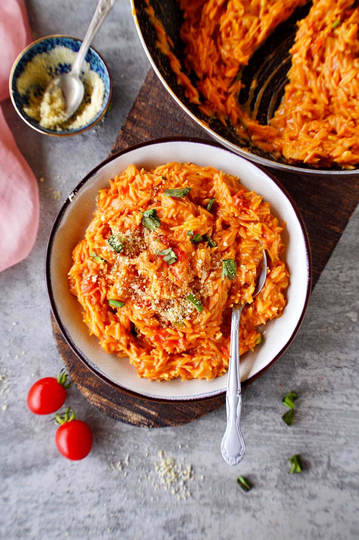 creamy orzo risotto in bowl with cherry tomatoes
