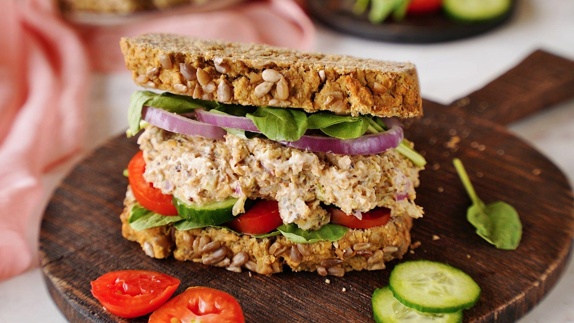 horizontal shot of chickpea tuna salad sandwich on wooden board