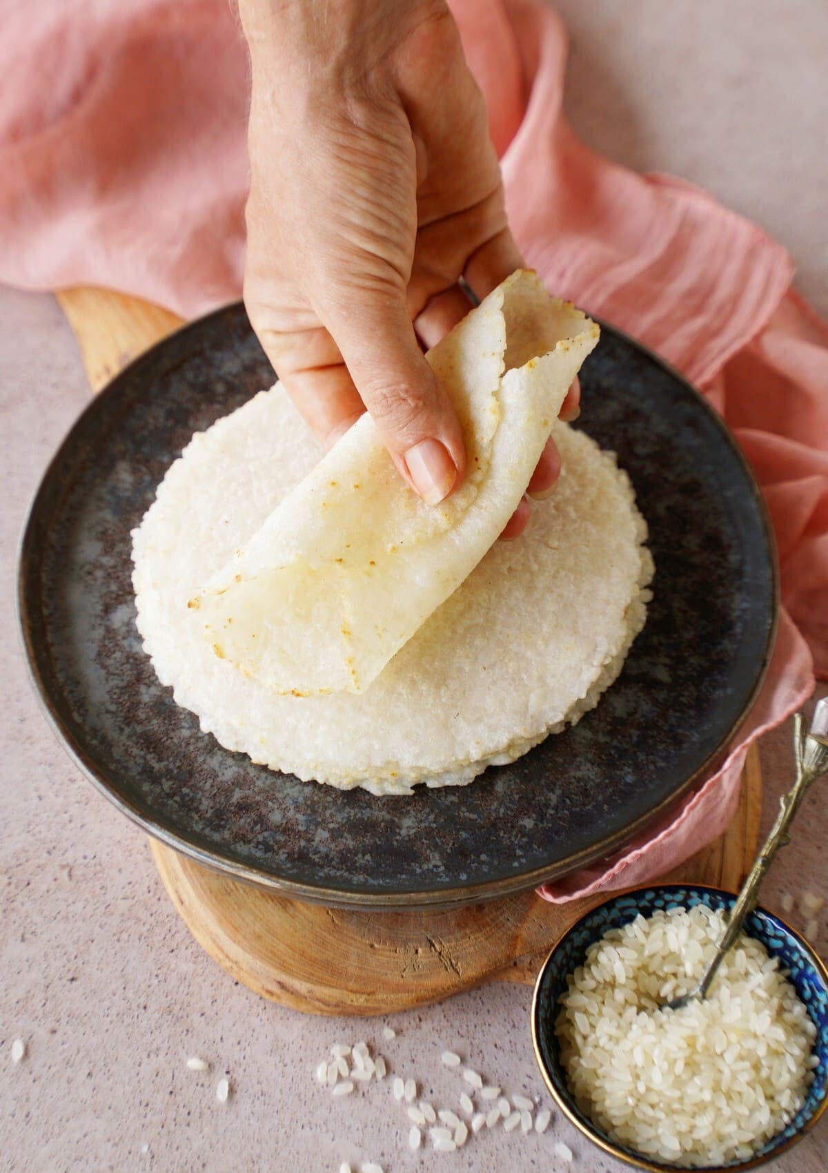 Hand, die eine gerollte glutenfreie Reis-Tortilla hält