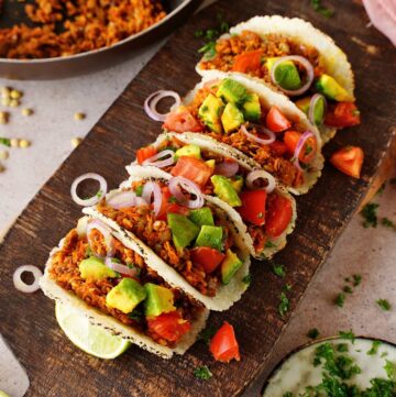 lentil tacos with tomato onion and avocado on wooden board
