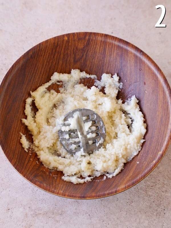 mashing rice with potato masher