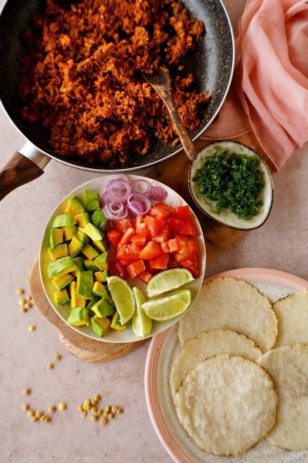 carrot and lentil walnut meat in pan with raw veggies and rice tortillas